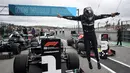 Pembalap Mercedes Lewis Hamilton melompat keluar dari mobilnya setelah memecahkan rekor kemenangan ke-92 di Formula 1 GP Portugaldi Algarve International Sirkuit, Portugal (25/10/2020). Berkat kemenangan itu, Hamilton mematahkan rekor milik Michael Schumacher. (Jorge Guerrero, Pool via AP)