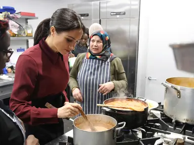 Duchess of Sussex Meghan Markle memasak bersama komunitas Hubb Community Kitchen di London, Inggris (21/11). Kegiatan Istri Pangeran Harry itu untuk melakukan proyek amal. (Chris Jackson/Pool via AP)