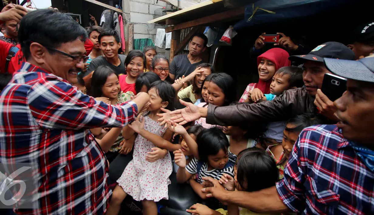 Warga berebut salaman dengan Djarot Saiful Hidayat usai Deklarasi Simpul Aliansi Masyarakat Sipil Untuk Indonesia Hebat (Almisbat) Untuk Pemenangan Basuki-Djarot di Kawasan Kapuk, Cengkareng, Jakarta Barat, Minggu (30/10). (Liputan6.com/Gempur M. Surya)