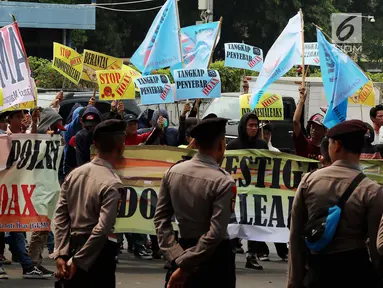 Petugas berjaga saat massa dari GEMA HOAX menggelar aksi di depan Mabes Polri, Jakarta, Rabu (17/10). Mereka menuntut dan mendesak Kapolri mengusut tuntas pelaku penyebar hoax investigasi Indonesialeaks dan Stop Hoax. (Liputan6.com/Johan Tallo)