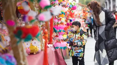 Orang-orang berbelanja lentera menjelang Festival Lampion, yang jatuh pada 15 Februari tahun ini - hari ke-15 Tahun Baru Imlek - di Nanjing di provinsi Jiangsu timur China pada 10 Februari 2022. Festival Lampion merupakan puncak sekaligus penutup dari perayaan Tahun Baru Imlek. (STR / AFP)
