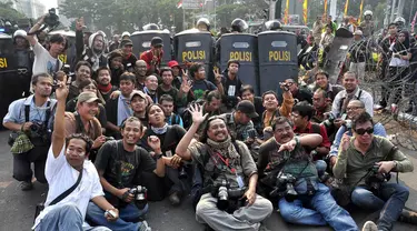 Sejumlah pewarta foto melakukan foto bersama usai demo di kawasan Patung Kuda, Jakarta, Kamis (21/8/14).(Liputan6.com/Miftahul Hayat)