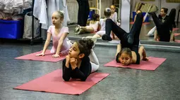 Gadis-gadis kecil mengikuti kelas balet di sebuah studio di Moskow , 22 November 2018. Orang tua dan kakek-nenek duduk di koridor sebuah studio kecil di Moskow utara menunggu anak-anak usia tiga tahun menyelesaikan kelas balet mereka. (Mladen ANTONOV/AFP)