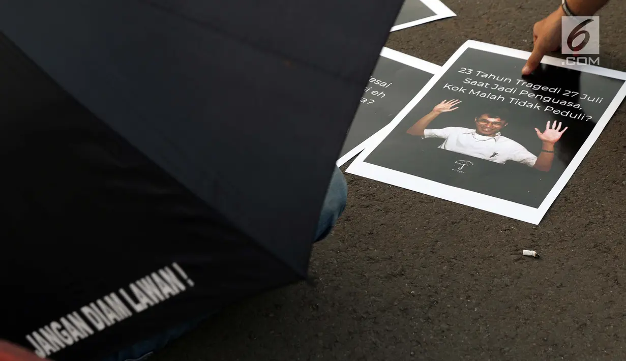 Aktivis yang tergabung dalam Jaringan Solidaritas Korban untuk Keadilan mengambil poster saat aksi Kamisan di depan Istana Negara, Jakarta, Kamis (25/7/2019). Aksi Kamisan ke-594 mengangkat tema '23 Tahun Tragedi 27 Juli Saat Jadi Penguasa Kok Malah Tidak Peduli?'. (Liputan6.com/Helmi Fithriansyah)