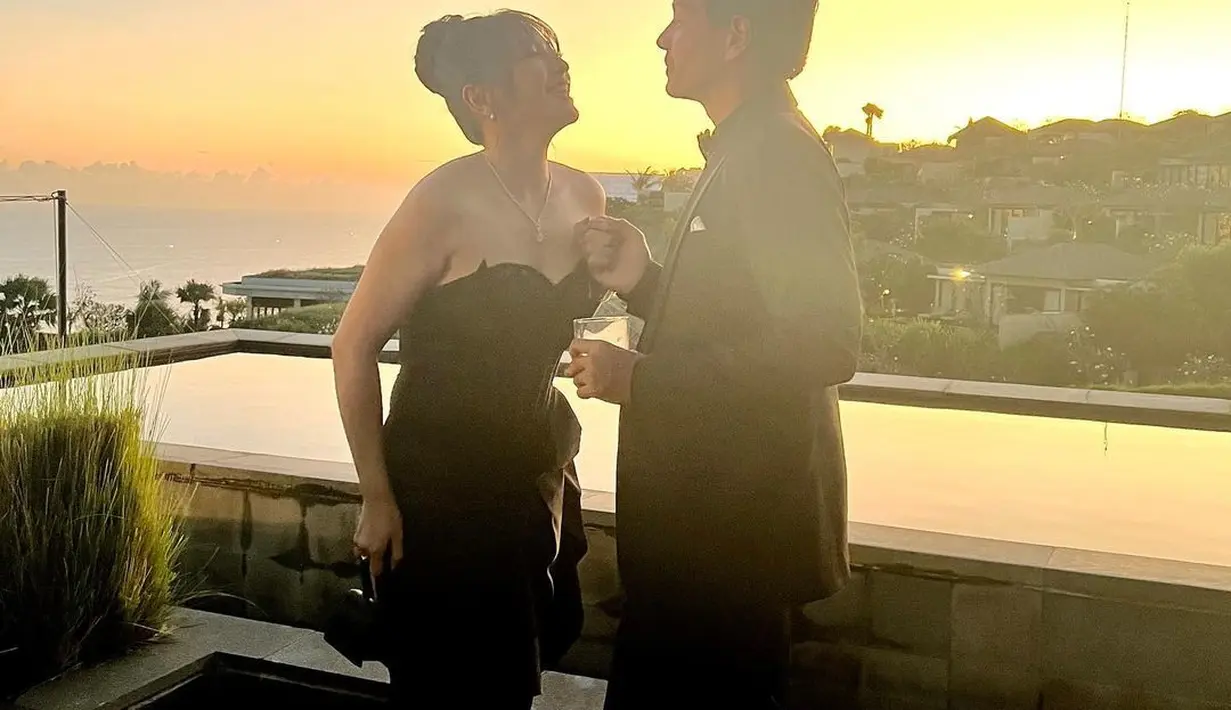 Gaun hitam Hesti menggabungkan detail korset dan rok slit yang seksi, dipadukan dengan lace socks [@hestipurwadinata]