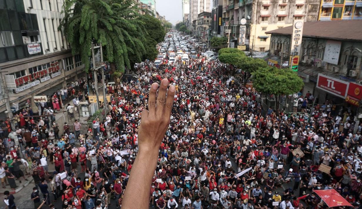 Seorang pengunjuk rasa mengacungkan salam tiga jari saat demonstrasi menentang kudeta militer di Yangon, Myanmar pada Sabtu (6/2/2021). Menurut saksi mata, aksi tersebut adalah demonstrasi jalanan terbesar yang berlangsung di Myanmar sejak kudeta hari Senin, 1 Februari lalu. (STR / AFP)