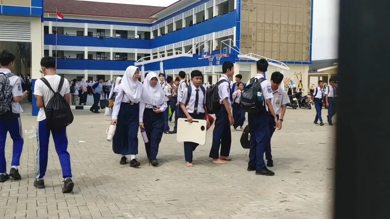 Sejumlah siswa membawa meja belajar sendiri dari rumah usai SMPN 3 Depok kekurangan bangku dan kursi untuk belajar. (Liputan6.com/Dicky Agung Prihanto)