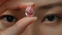 Model memperlihatkan berlian berwarna purple pink yang sangat langka di ruang lelang Sotheby Hong Kong pada 12 Oktober 2020. Rumah lelang Sotheby mengungkapkan, berlian itu diperkirakan akan terjual hingga 38 juta dolar AS (atau sekitar Rp 561 miliar). (AP Photo/Vincent Yu)