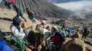 Warga Tengger mendaki Gunung Bromo membawa persembahan hasil bumi selama Festival Yadnya Kasada di Probolinggo, Jawa Timur (10/7). Warga Tengger melakukan ritual lempar hasil bumi sebagai wujud syukur pada Sang Hyang Widi. (AFP Photo/Juni Kriswanto)