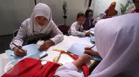 Seorang siswi mengisi formulir Penerimaan Peserta Didik Baru (PPDB) tahun ajaran 2016/2017 di Dinas Pendidikan Kota Yogyakarta, Rabu (15/6). PPDB jalur Kartu Menuju Sehat (KMS) diminati siswa untuk mendapatkan sekolah favorit. (Liputan6.com/Boy Harjanto)