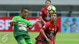 Penyerang PS TNI, Roni Sugeng Ariyanto (kiri) berebut bola dengan pemain Persiba pada laga lanjutan Liga 1 Indonesia di Stadion Pakansari, Kab Bogor, Jumat (5/5). Laga kedua tim berakhir imbang 1-1. (Liputan6.com/Helmi Fithriansyah)