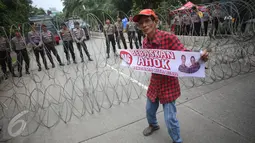 Seorang pendukung Basuki Tjahaja Purnama (Ahok) asyik berjoget sambil membentangkan spanduk saat berlangsungnya sidang kasus dugaan penistaan agama di depan Gedung Kementerian Pertanian (Kementan), Jakarta, Selasa (31/1). (Liputan6.com/Immanuel Antonius)