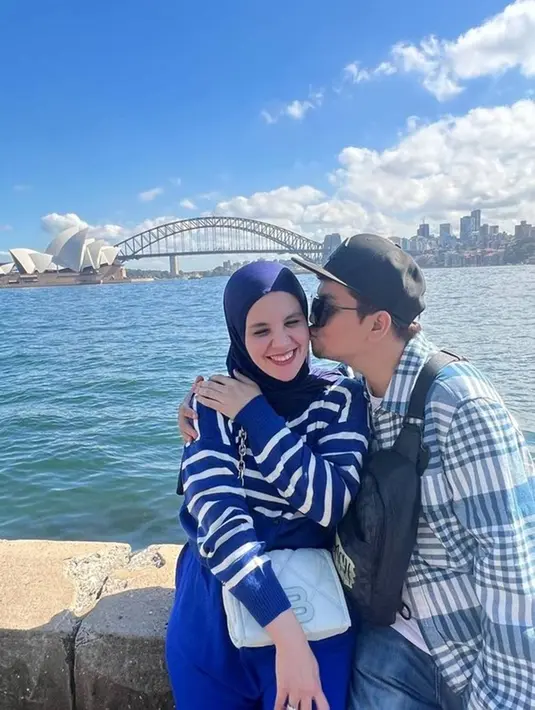 Dalam liburannya di Negeri Kanguru ini pasangan Indra Bekti dan Aldila Jelita tidak sungkan untuk membagikan potret kemesraannya. Keduanya nampak abadikan momen bersama di depan bangunan ikonik, yaitu Gedung Opera Sydney.  (Liputan6.com/IG/@indrabekti)