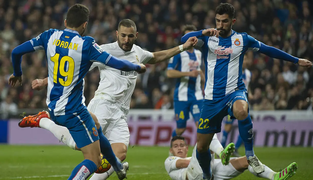 Striker Real Madrid, Karim Benzema, dihadang pemain Espanyol, Joan Jordan Moreno dan Alvaro Gonzalez ppada laga La Liga. Penyerang asal Prancis itu mencetak gol pembuka Madrid di menit ke-7. (AFP/Curto De La Torre)