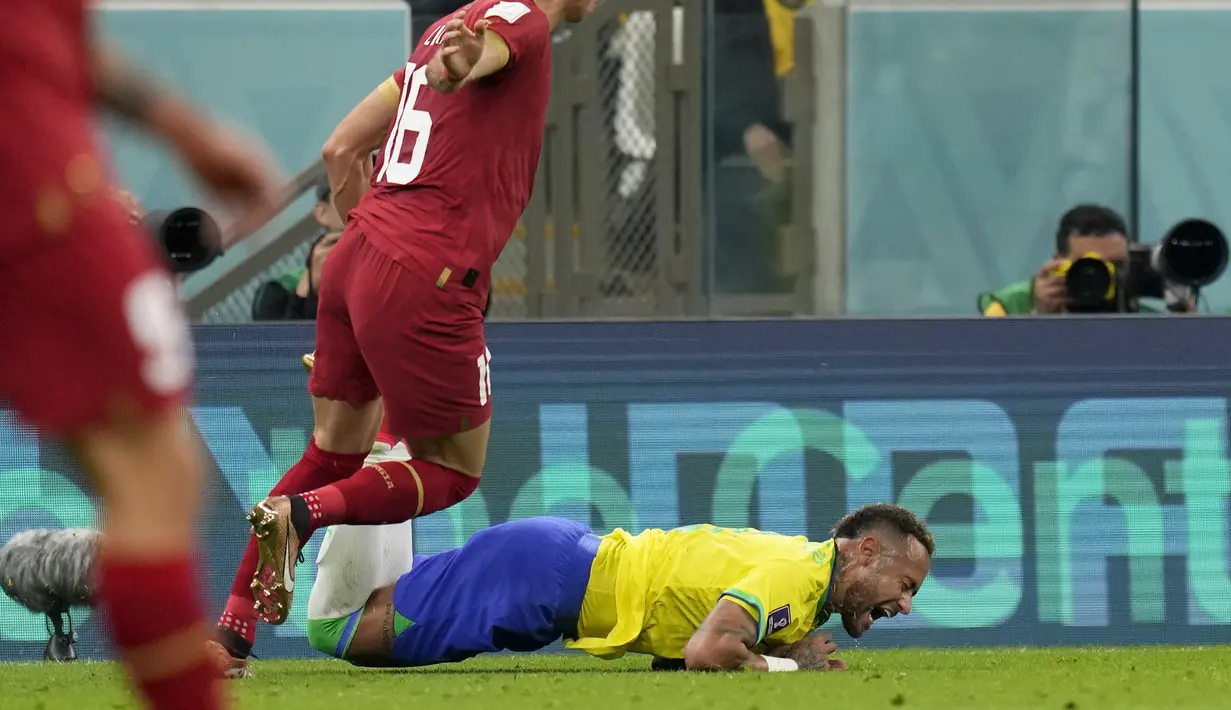 Penyerang Brasil, Neymar jatuh ke tanah di depan gelandang Serbia Sasa Lukic pada  matchday 1 Grup G Piala Dunia 2022 di Stadion Lusail Iconic, Jumat (25/11/2022) dini hari WIB. Bintang mereka, Neymar Jr mendapat cedera cukup serius dalam pertandingan itu. (AP Photo/Andre Penner)