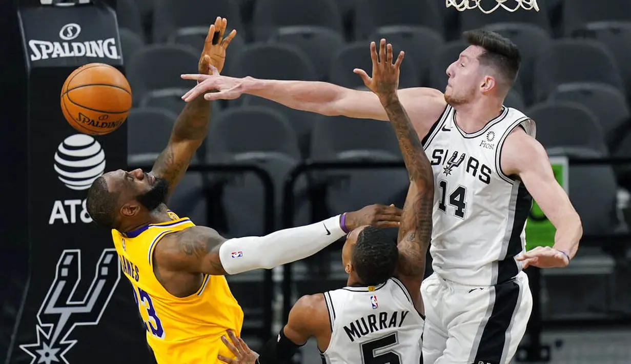 Pebasket Los Angeles Lakers, LeBron James, berebut bola dengan pebasket San Antonio Spurs, Drew Eubanks, pada laga NBA di AT&T Center, Kamis (31/12/2020). LA Lakers menang dengan skor 121-107. (AP/Eric Gay)