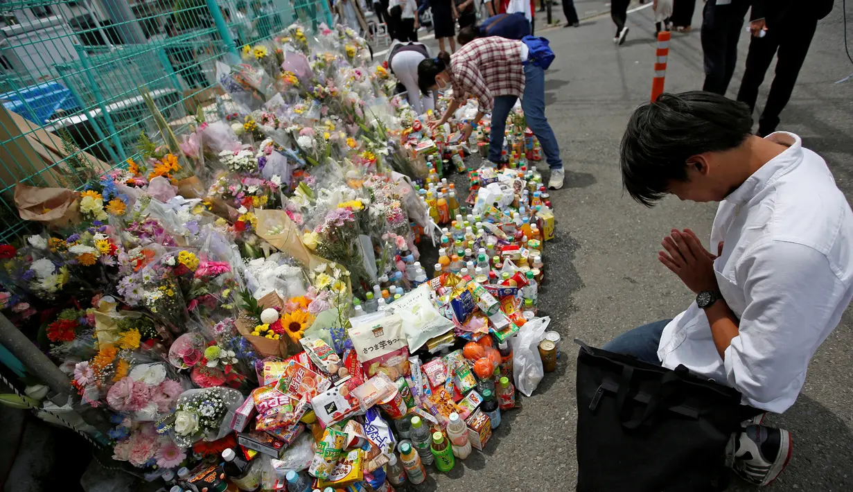 Seorang pria berdoa untuk orban Penikaman Massal yang terjadi di Kawasaki, Jepang (29/5/2019). Pelaku yang disebut berusia 50-an tahun, ditangkap polisi setelah menikam dirinya sendiri di bagian leher. (Reuters/Issei Kato)