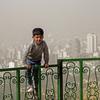 Seorang anak laki-laki bermain di luar selama badai pasir besar di utara ibu kota Iran, Teheran pada 17 Mei 2022. Kantor-kantor pemerintah, serta sekolah dan universitas diumumkan ditutup di banyak provinsi di Iran karena kondisi "cuaca tidak sehat" dan badai pasir yang menyelimuti, menurut laporan media pemerintah. (AFP)