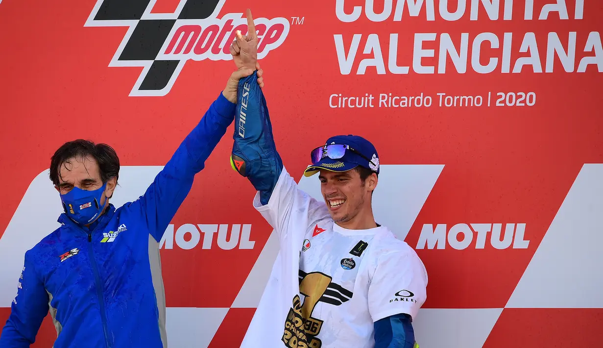 Pembalap Suzuki Ecstar, Joan Mir (kanan) merayakannya dengan Manajer Tim Davide Brivio setelah memenangkan kejuaraan dunia MotoGP setelah Grand Prix Valencia di sirkuit Ricardo Tormo di Valencia  (15/11/2020). (AFP/Lluis Gen)