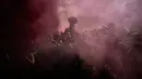 Para pengunjuk rasa berdiri di bawah asap suar saat demonstrasi di Marseille, Prancis, 18 Oktober 2022. Prancis berada dalam cengkeraman pemogokan transportasi dan protes untuk kenaikan upah. (AP Photo/Daniel Cole)