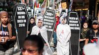 Buruh mengenakan kostum pocong selama unjuk rasa peringatan May Day di Hong Kong, Senin (1/5). Pekerja di berbagai belahan dunia mengadakan aksi Hari Buruh Internasional dengan memadati jalan-jalan besar untuk menyuarakan aspirasi (Richard A. Brooks/AFP)