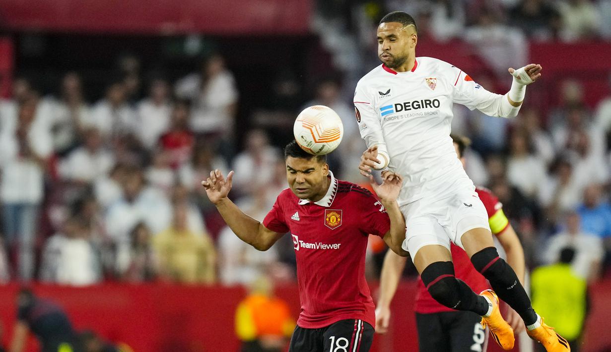 Pemain Manchester United, Casemiro, duel udara dengan pemain Sevilla, Youssef En-Nesyri, pada leg kedua perempat final di Ramon Sanchez Pizjuan, Jumat (21/4/2023). Pemain yang memiliki segudang pengalaman di kompetisi Eropa ini tampil melempem saat melawan Sevilla. Sebagai gelandang bertahan, ia sama sekali tidak memberikan perlindungan ekstra kepada pertahanan MU yang sangat rapuh. (AFP/Jorge Guerreo)