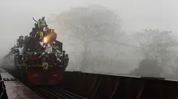 Kereta api yang penuh sesak terlihat berjalan di atas rel mengangkut umat Muslim yang baru selesai mengikuti  Akheri Munajat, atau doa terakhir, di Biswa Ijtema, Bangladesh  10 Januari 2016. (AFP PHOTO/Munir uz ZAMAN)