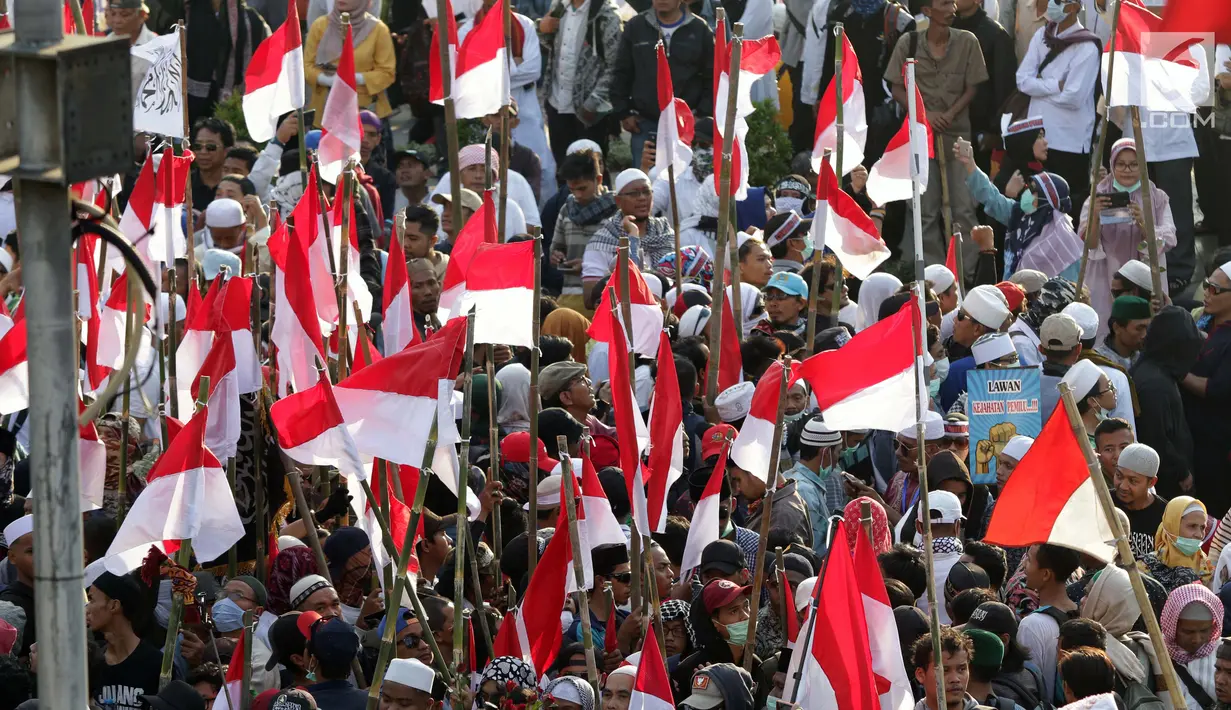 Peserta aksi massa Gerakan Nasional Kedaulatan Rakyat mengibarkan bendera Merah Putih saat melakukan unjuk rasa di depan Gedung Bawaslu, Jakarta, Selasa (21/5/2019). Mereka menolak hasil Pemilu 2019 yang dinilai banyak terdaopat kecurangan. (Liputan6.com/Helmi Fithriansyah)