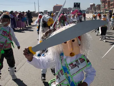Siswa mengenakan topeng dari wadah minyak goreng plastik sambil menari "Paquchi" pada festival di Bolivia, Selasa (14/8). Siswa sekolah San Roque membuat kostum dari bahan daur ulang untuk meningkatkan kesadaran pengelolaan limbah padat. (AP/Juan Karita)