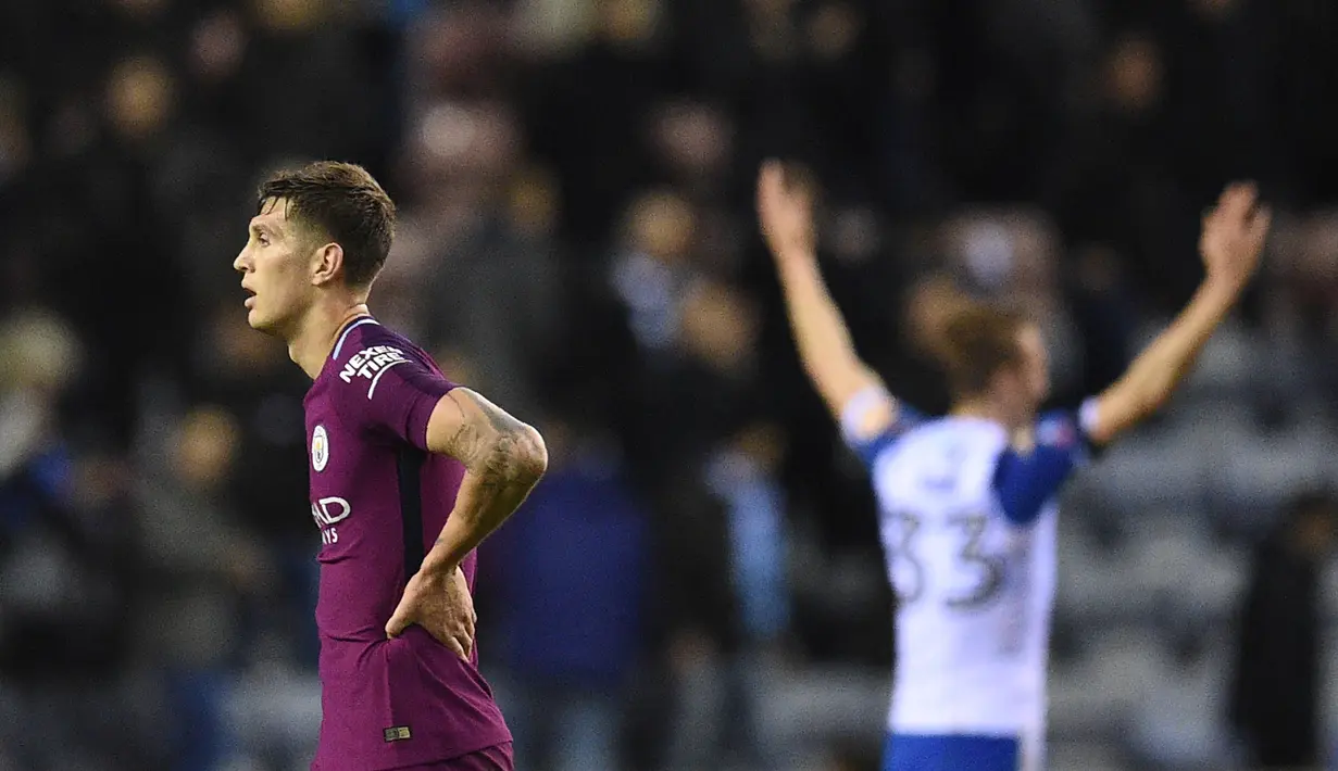 Bek Manchester City John Stones bereaksi usai akhir babak kelima Piala FA saat bertandang ke markas Wigan Athletic di DW Stadium, Senin (19/2). Manchester City menyerah 0-1 dari Wigan Athletic. (Oli SCARFF / AFP)