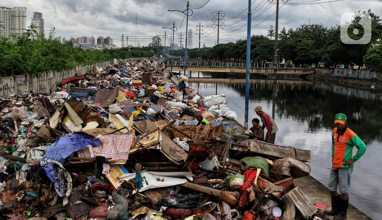 Warga memilah sampah sisa banjir yang dikumpulkan dari sepanjang Kali Cengkareng, Jakarta Barat, Kamis (9/1/2020). Tumpukan sampah di sepanjang bantaran kali dan rumah-rumah warga terlihat setelah banjir yang melanda sejumlah kawasan Jakarta mulai surut. (Liputan6.com/Johan Tallo)
