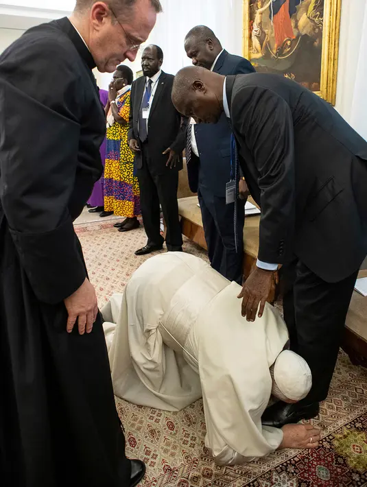 Paus Fransiskus berlutut dan mencium kaki Wakil Presiden Sudan Selatan Taban Deng Gai dalam pertemuan di Vatikan, Kamis (11/4). Dalam pertemuan itu, Paus Fransiskus mencium kaki baik pejabat pemerintah maupun oposisi guna mencegah para pemimpin itu kembali ke perang saudara. (Vatican Media via AP)