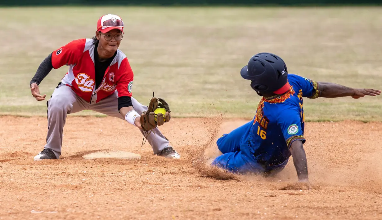 DP. Djoepari dari Papua Barat sliding ke base 2 pada pertandingan kedua babak penyisihan softball putra PON XX Papua antara DKI Jakarta vs Papua Barat di Lapangan Softball Uncen, Kota Jayapura, Rabu (22/09/2021). (Foto : PB PON XX PAPUA/Robertus Pudyanto)