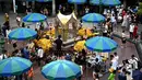 Para jemaat berdoa di Kuil Erawan di Bangkok pada 9 Juli 2019 (atas) dan pada 6 Maret 2020. (Mladen ANTONOV, Permata SAMAD/AFP)