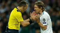 Pemain Real Madrid Luka Modric melakukan protes terhadap wasit saat melawan Bayern Munchen dalam pertandingan semifinal Liga Champions di stadion Santiago Bernabeu, Spanyol (1/5). (AP/Paul White)