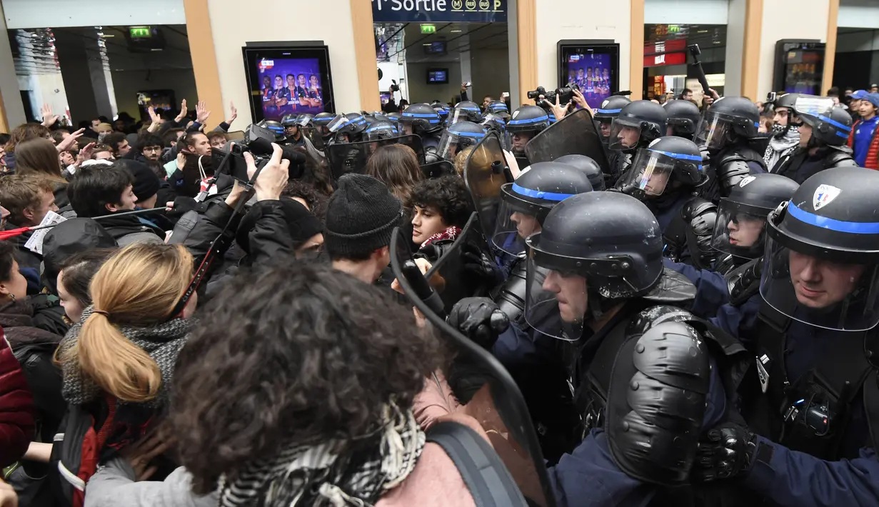 Aksi saling dorong antara demonstran dan polisi di dekat Stasiun Saint-Lazare, Paris, Perancis, Selasa (12/4). Demonstran menentang reformasi hukum perburuhan yang dirancang pemerintah Perancis. (AFP Photo/ Dominique Faget)