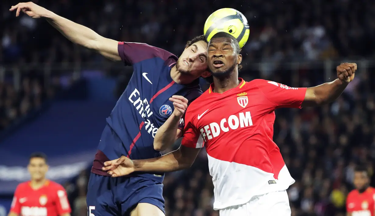 Gelandang PSG, Adrien Rabiot, duel udara dengan bek AS Monaco, Almamy Toure, pada laga Ligue 1 di Stadion Parc des Princes, Prancis, Minggu (15/4/2018). PSG menang 7-1 atas Monaco. (AFP/Thomas Samson)