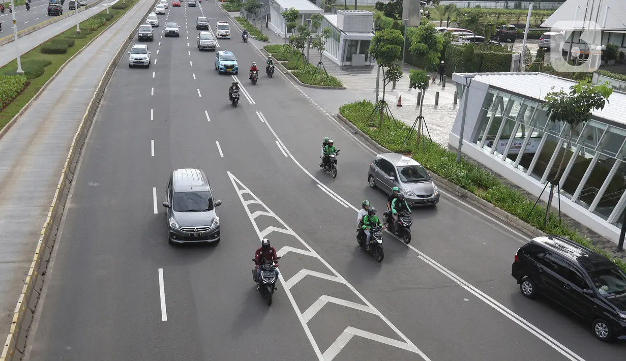 Pengendara motor melintasi kawasan Sudirman, Jakarta, Minggu (2/2/2020).  Ditlantas Polda Metro Jaya akan melakukan penindakan pelanggran E-TLE untuk sepeda motor mulai Senin (3/2), mulai hari kerja. (Liputan6.com/Herman Zakharia)