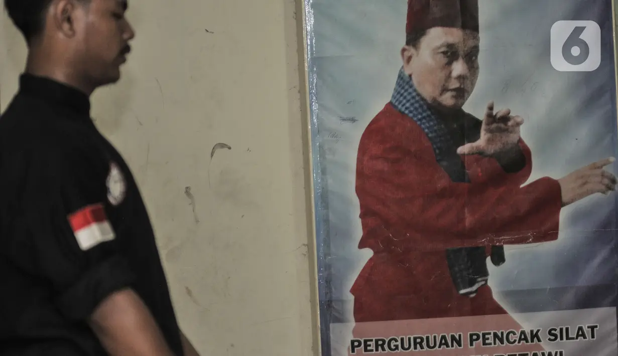 Salah seorang murid melintasi foto Kong Sulaiman, guru silat Iwan. (merdeka.com/Iqbal S Nugroho)