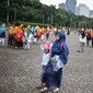 Sejumlah pengunjung berjalan-jalan di kawasan Monumen Nasional (Monas), Jakarta, Sabtu (22/12). Libur sekolah yang berbarengan dengan libur Natal dan Tahun Baru dimanfaatkan masyarakat untuk pergi berwisata ke Monas. (Liputan6.com/Faizal Fanani)