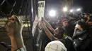 Sejumlah pengunjuk rasa melakukan protes di dekat kediaman presiden di Mexico City, Meksiko, (26/11). Ratusan aktivis turun kejalan untuk menuntut keadilan 43 siswa yang hilang. (REUTERS/Daniel Becerril)