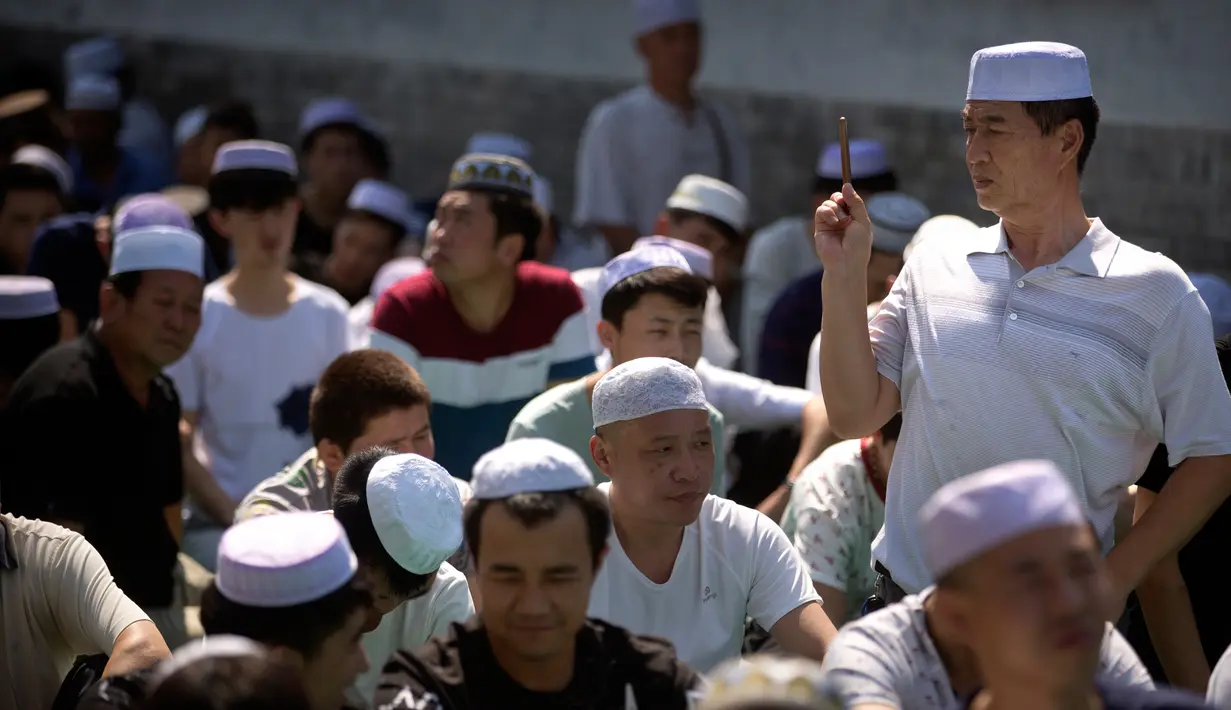 Seorang pria muslim Cina mengambil gambar selama pelaksanaan salat Idul Fitri di masjid Niujie, Beijing, 26 Juni 2017. Umat muslim di berbagai penjuru dunia merayakan Idul Fitri, yang menandai berakhirnya bulan suci Ramadan. (AP Photo/Mark Schiefelbein)