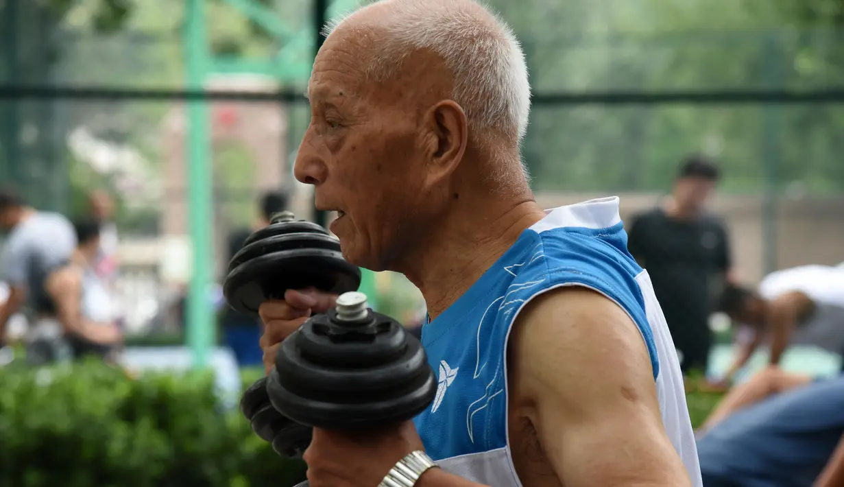 Li Chunfu (92) mengangkat dumbel sebelum latihan bola basket di Jinan, Provinsi Shandong, China, Rabu (5/8/2020). Li mengatakan, bermain basket dan latihan beban membuatnya mempertahankan kondisi fisik dan mental yang baik. (Xinhua/Wang Kai)