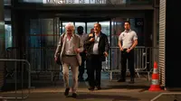 Michel Platini didampingi pengacara William Bourdon meninggalkan Kantor Satgas Antikorupsi Prancis, Rabu (19/6/2019) dini hari waktu setempat. (AFP/Zakaria Abdelkafi)