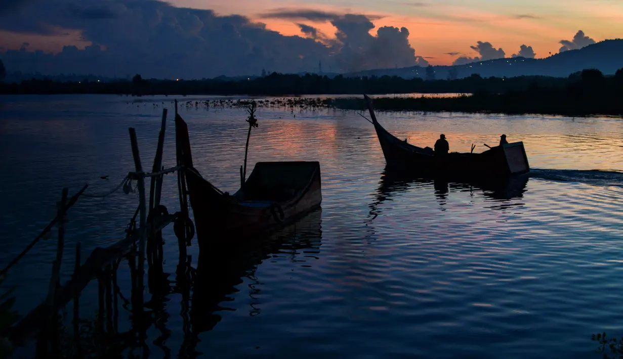 Nelayan berangkat melaut dengan perahu mereka saat fajar pada Hari Bumi di pantai Kajhu, provinsi Aceh (22/4/2021).  Kini hari bumi diperingati di lebih dari 175 negara dan dikoordinasi secara global oleh Jaringan Hari Bumi. (AFP/Chaideer Mahyuddin)