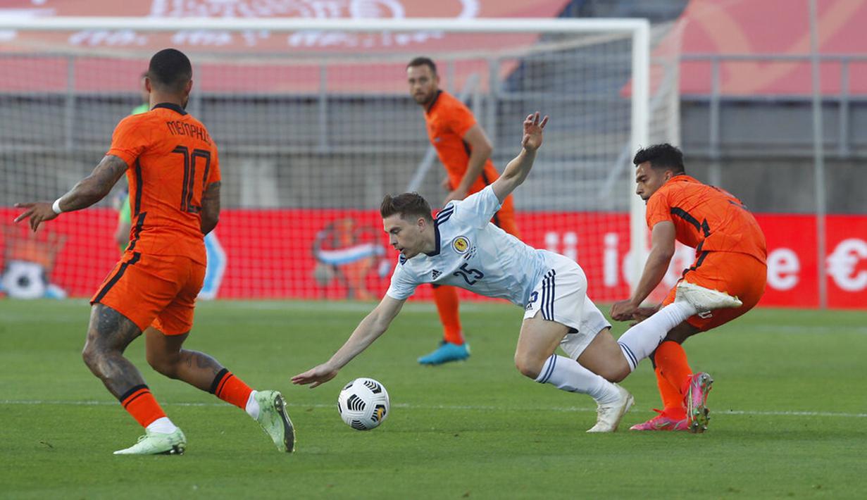 Pemain Skotlandia James Forrest (tengah) terjatuh saat melawan Belanda pada pertandingan persahabatan di Stadion Algarve, luar Faro, Portugal, Rabu (2/6/2021). Pertandingan berakhir imbang 2-2. (AP Photo/Miguel Morenatti)