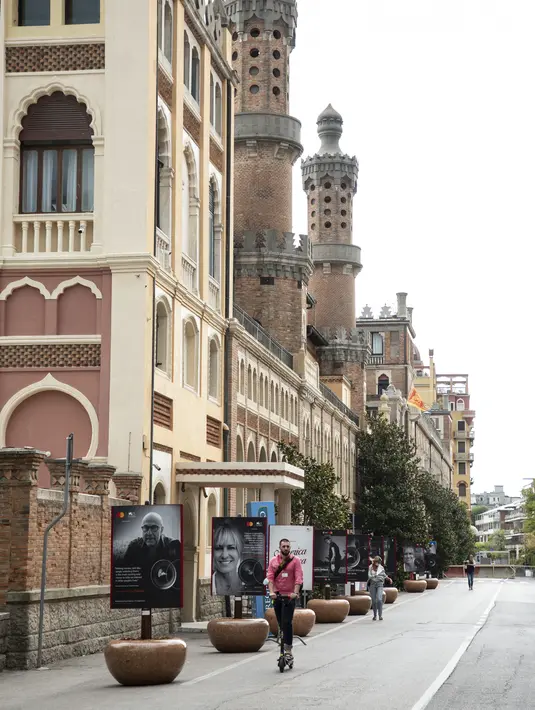 Seorang pria mengendarai skuter listrik di depan hotel Excelsior sehari sebelum dimulainya Festival Film Venesia edisi ke-78 di Venice Lido, Italia, Selasa (30/8/2021).  Festival ini berlangsung dari 1 hingga 11 September. (Photo by Joel C Ryan/Invision/AP)