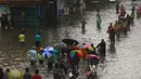 Orang-orang mengarungi jalan yang banjir setelah hujan lebat di Chennai, India (8/11/2021). Chennai dilanda Curah Hujan Terberat Sejak 2015,  Pihak berwenang Keluarkan Peringatan Banjir. (AFP/Arun Sankar)