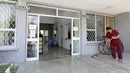 Seorang wanita mengepel pintu masuk kampus mahasiswa yang akan menampung warga Afghanistan, di Tirana, Albania, Rabu (18/8/2021).  Albania sedang mempersiapkan kedatangan warga Afganistan yang bekerja dengan pasukan penjaga perdamaian Barat yang terancam Taliban. (AP Photo/Franc Zhurda)