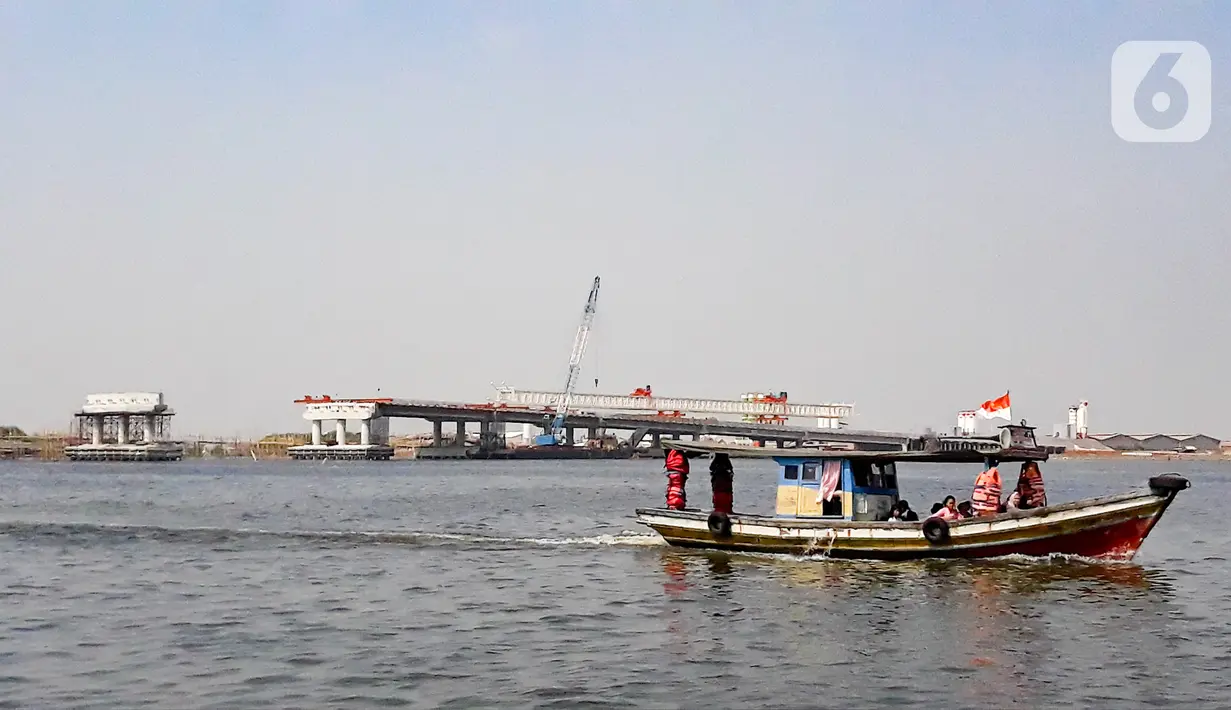 Kapal tradisional melintas dekat proyek pembangunan jembatan penghubung Dadap Tangerang-Pulau C di Kamal Muara, Penjaringan, Jakarta Utara, Minggu (17/11/2019). Jembatan tersebut nantinya akan menghubungkan wilayah Dadap di Tangerang dengan reklamasi Pulau C di Jakarta. (merdeka.com/Iqbal Nugroho)